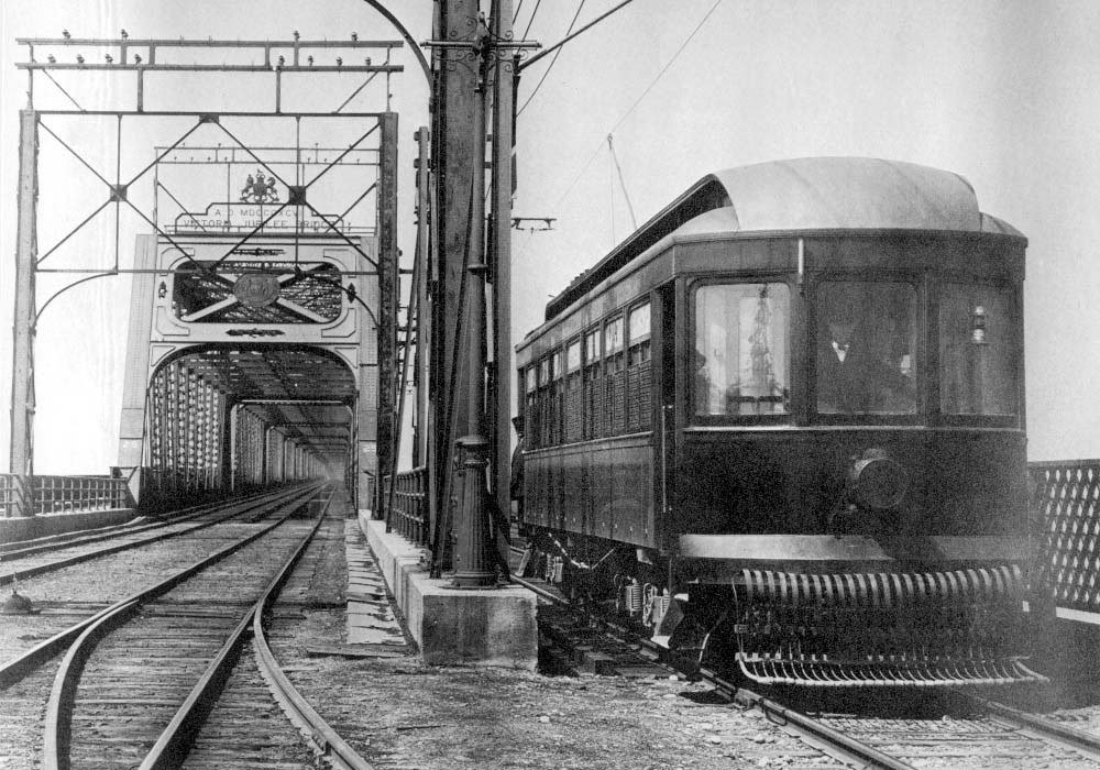 Le premier tramway du Montreal & Southern Counties arrive à Saint-Lambert via le pont Victoria. 1909. Wikimedia commons/Domaine public.